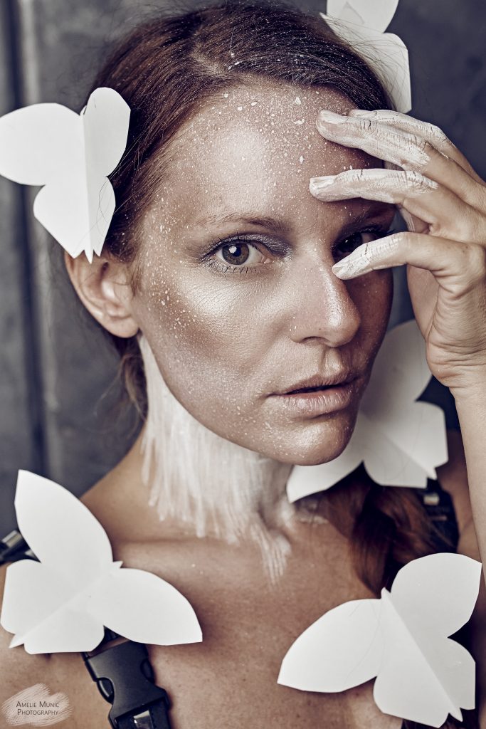 Portrait-einer-frau-mit-weißen-papier-schmetterlingen